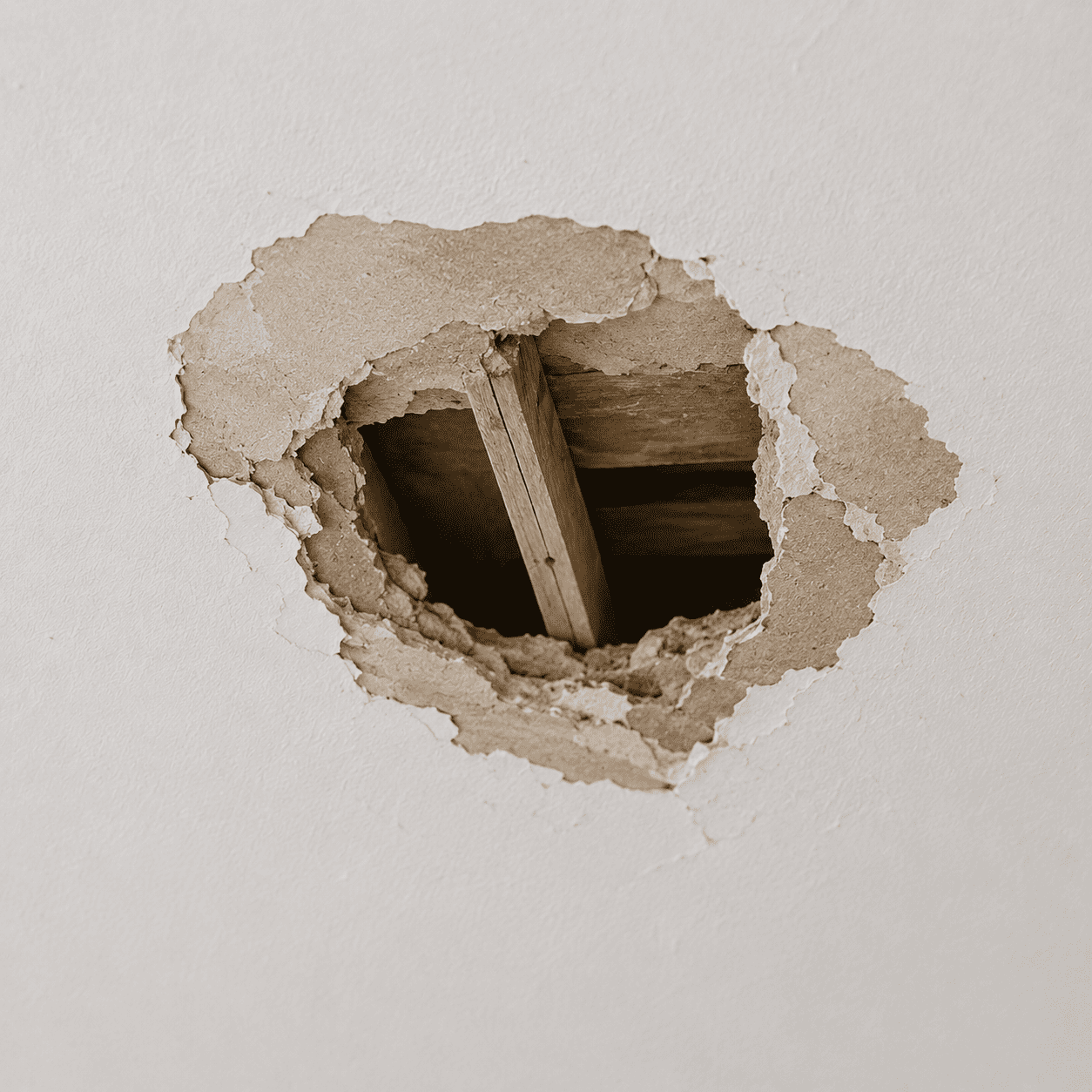 Hole and impact damage in a drywall ceiling